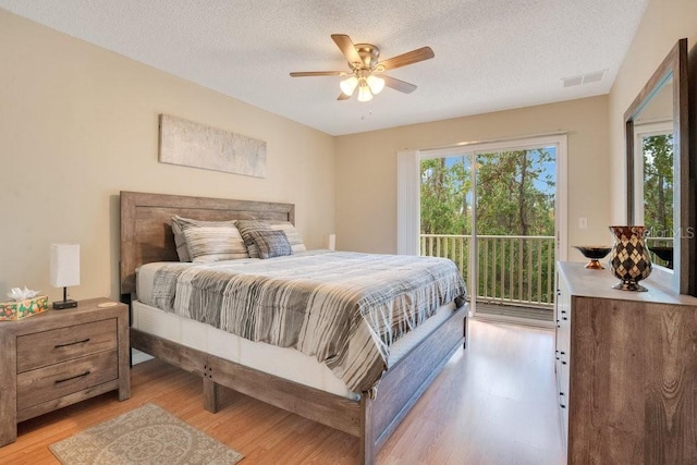 bedroom featuring access to outside, light hardwood / wood-style floors, a textured ceiling, and ceiling fan