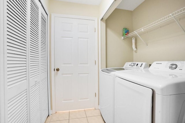 washroom with washing machine and clothes dryer and light tile patterned floors