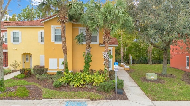 8447 Crystal Cove Loop, Kissimmee, FL 34747 - view of front of property with a tiled roof, stucco siding, and a front yard