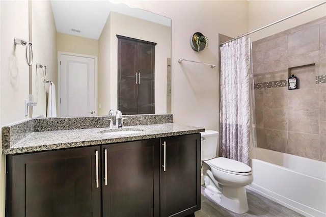 full bathroom featuring hardwood / wood-style flooring, shower / bathtub combination with curtain, vanity, and toilet