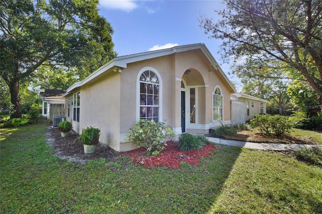 view of front facade with cooling unit and a front yard