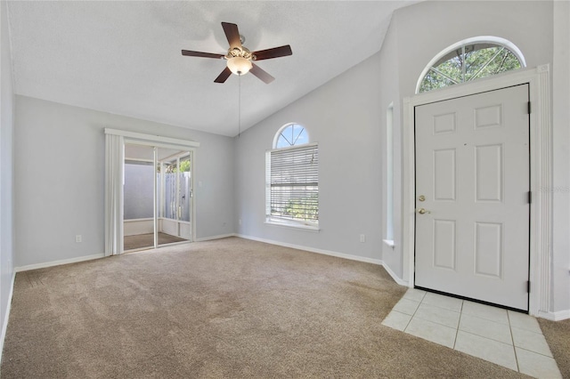 foyer with a textured ceiling, plenty of natural light, ceiling fan, and light colored carpet