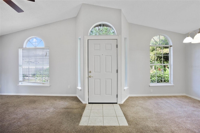 foyer entrance with vaulted ceiling, light carpet, and ceiling fan