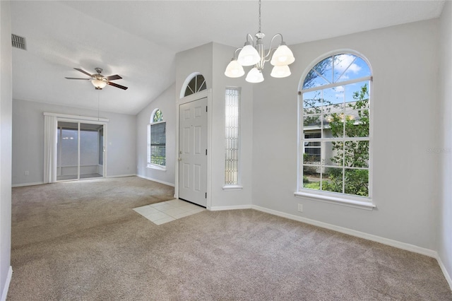 interior space with lofted ceiling, a healthy amount of sunlight, and ceiling fan with notable chandelier