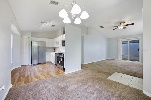 kitchen with white cabinetry, appliances with stainless steel finishes, light hardwood / wood-style flooring, lofted ceiling, and pendant lighting