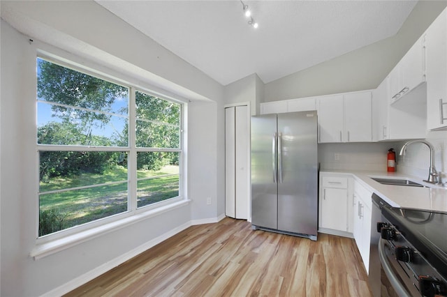 kitchen with stainless steel appliances, lofted ceiling, sink, and plenty of natural light