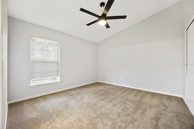 carpeted spare room featuring ceiling fan and vaulted ceiling