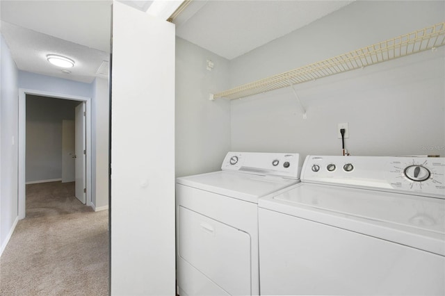 laundry room featuring washing machine and dryer and light carpet