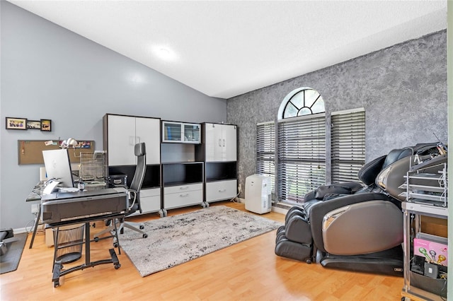 office area with light wood-type flooring and vaulted ceiling