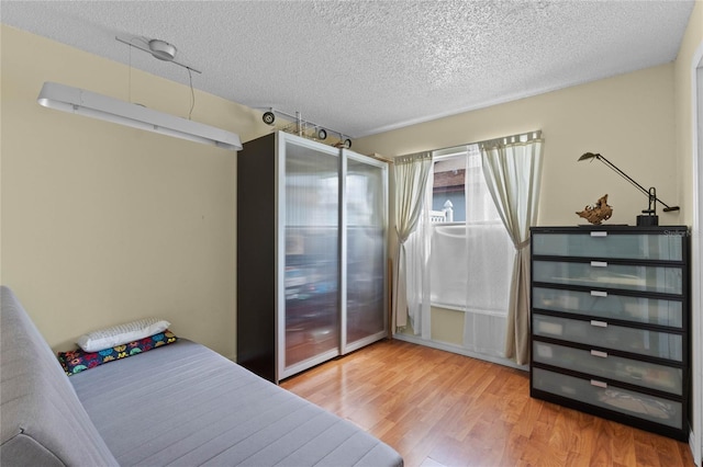 bedroom featuring hardwood / wood-style floors and a textured ceiling