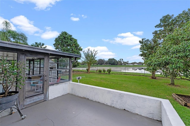 view of patio featuring a sunroom, a water view, and a rural view