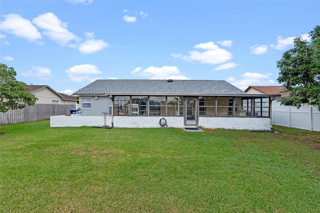 back of property featuring a lawn and a sunroom