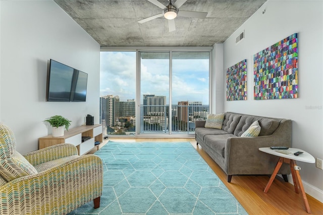 living room featuring expansive windows, hardwood / wood-style floors, and ceiling fan