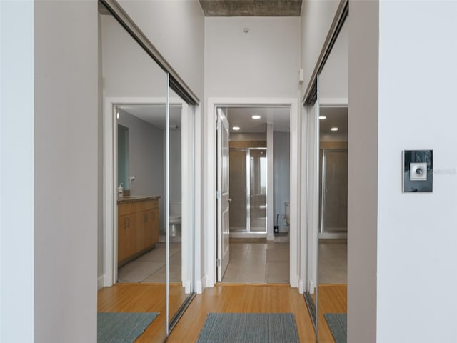 corridor featuring light hardwood / wood-style floors and a high ceiling