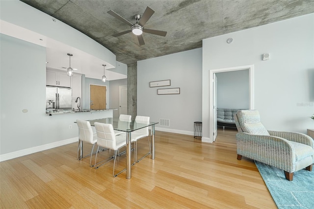 dining room featuring light hardwood / wood-style flooring, ceiling fan, and sink