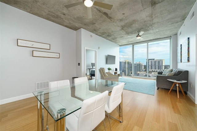 dining room with expansive windows, light wood-type flooring, and ceiling fan