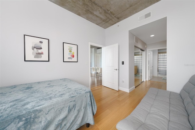 bedroom with connected bathroom and light hardwood / wood-style floors