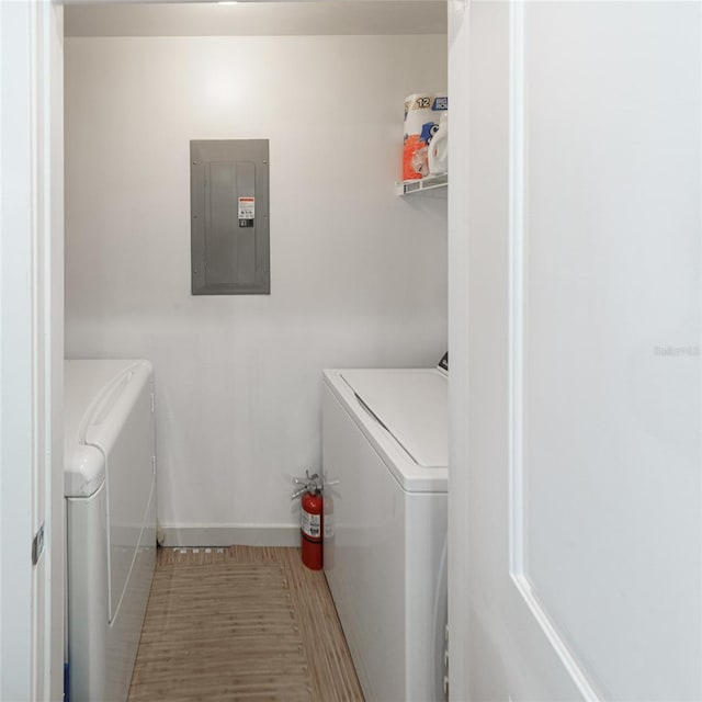 laundry room featuring electric panel, washing machine and dryer, and tile patterned floors