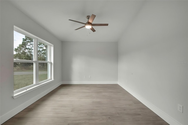 empty room with ceiling fan, a healthy amount of sunlight, and hardwood / wood-style flooring