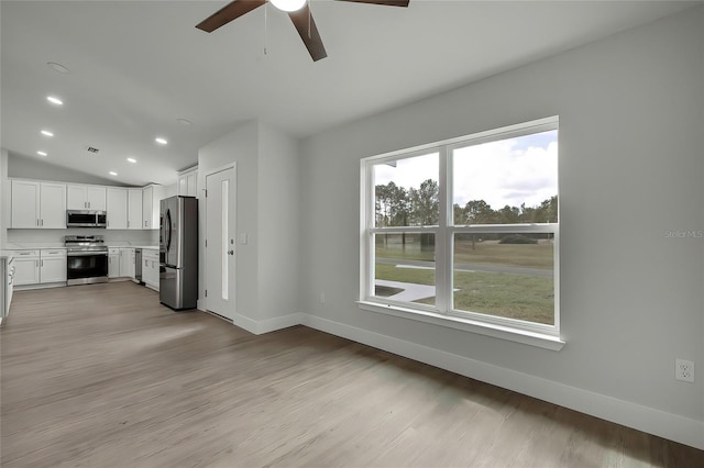 kitchen with white cabinetry, plenty of natural light, stainless steel appliances, and lofted ceiling