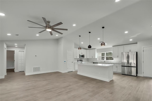 kitchen featuring white cabinets, a center island, stainless steel appliances, and light hardwood / wood-style flooring