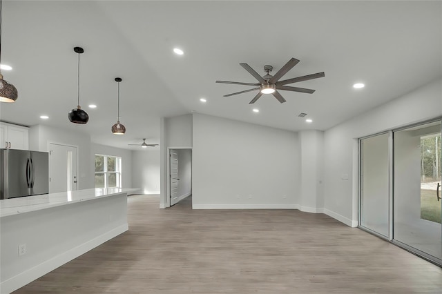 kitchen featuring stainless steel refrigerator, white cabinetry, a healthy amount of sunlight, and light wood-type flooring