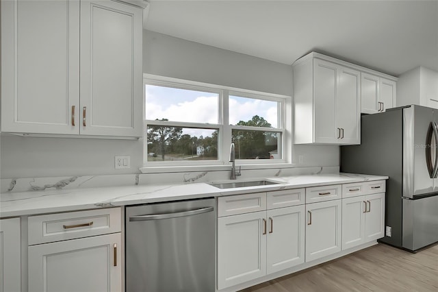 kitchen featuring white cabinets, sink, light hardwood / wood-style flooring, and stainless steel appliances