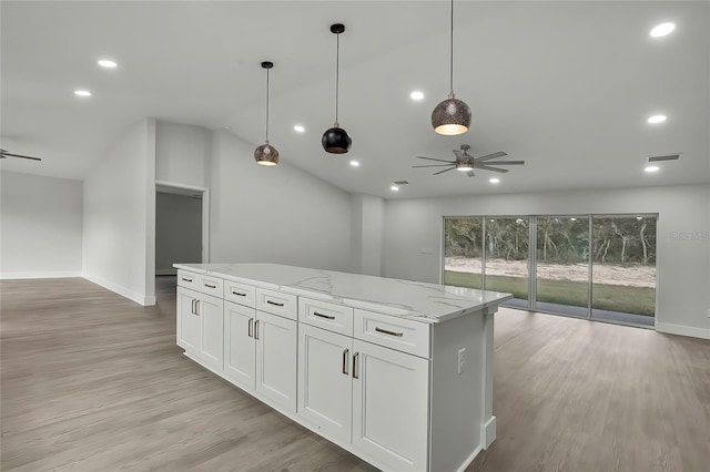 kitchen with white cabinets, pendant lighting, light wood-type flooring, ceiling fan, and light stone countertops