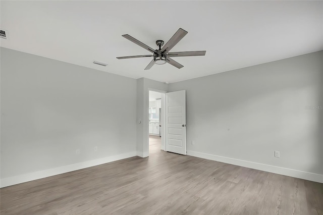 empty room with ceiling fan and light hardwood / wood-style flooring