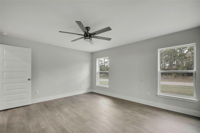 spare room featuring light hardwood / wood-style flooring and ceiling fan