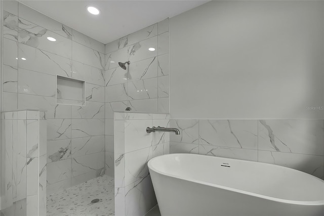 bathroom with separate shower and tub and tile walls