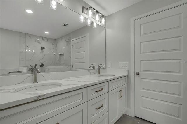 bathroom featuring vanity, tiled shower, and tile patterned flooring