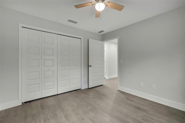 unfurnished bedroom with ceiling fan, a closet, and light wood-type flooring