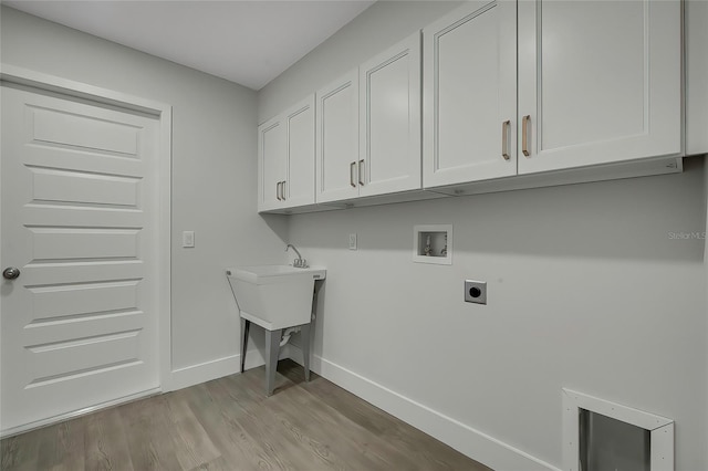 laundry area with electric dryer hookup, washer hookup, cabinets, and light hardwood / wood-style floors