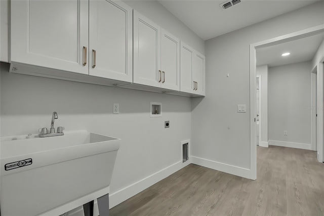 laundry room featuring cabinets, hookup for a washing machine, hookup for an electric dryer, sink, and light hardwood / wood-style flooring