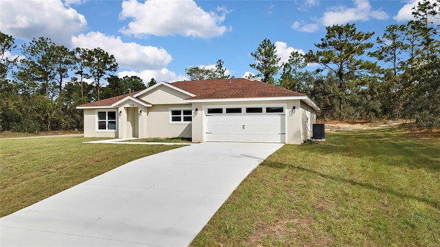 view of front of property with central AC unit, a front yard, and a garage