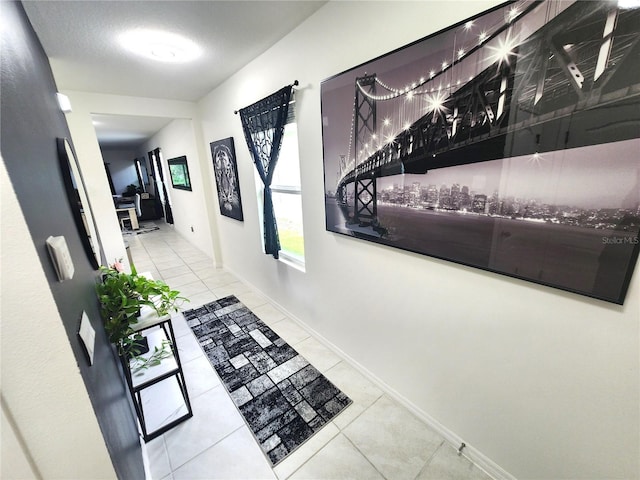 corridor with a textured ceiling and light tile patterned floors