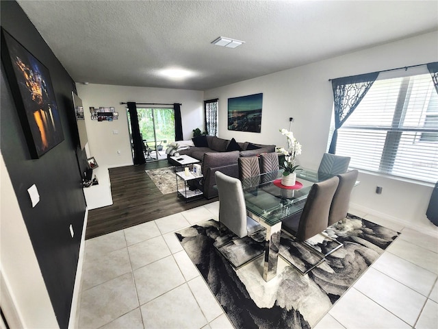 dining area featuring light hardwood / wood-style floors and a textured ceiling