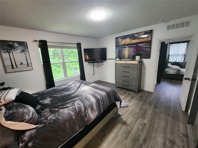 bedroom with hardwood / wood-style floors and a textured ceiling