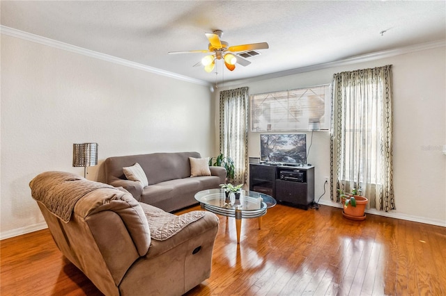 living room with ornamental molding, hardwood / wood-style flooring, ceiling fan, and a healthy amount of sunlight