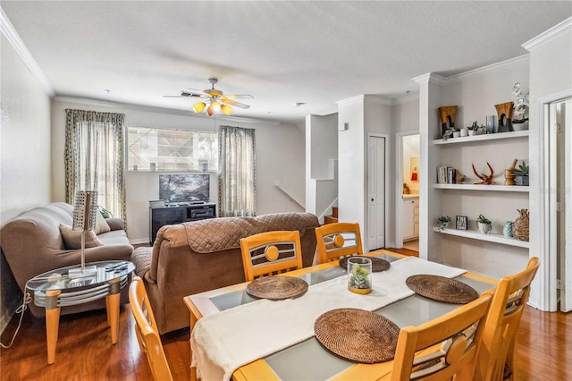 dining room with hardwood / wood-style floors, a textured ceiling, ceiling fan, and ornamental molding