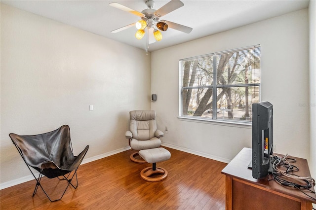 living area featuring hardwood / wood-style flooring and ceiling fan