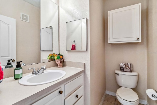 bathroom featuring toilet, vanity, and tile patterned floors