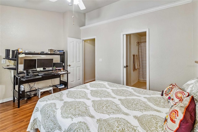 bedroom featuring hardwood / wood-style floors, ceiling fan, crown molding, and ensuite bath