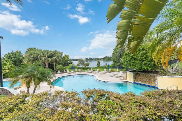 view of pool with a patio area and a water view