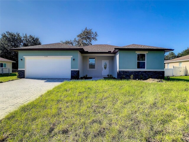 1543 Mackinaw St, North Port, FL 34286 - ranch-style home with an attached garage, stucco siding, decorative driveway, and stone siding