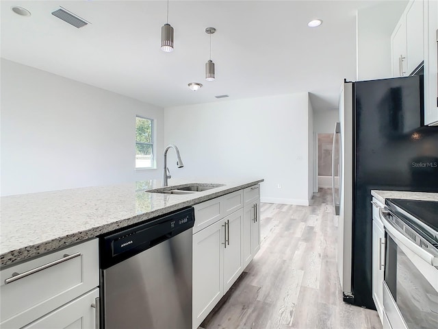 kitchen featuring white cabinetry, appliances with stainless steel finishes, sink, and light stone counters