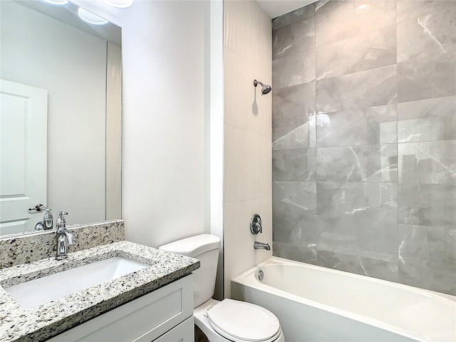 full bathroom featuring vanity, tiled shower / bath combo, and toilet