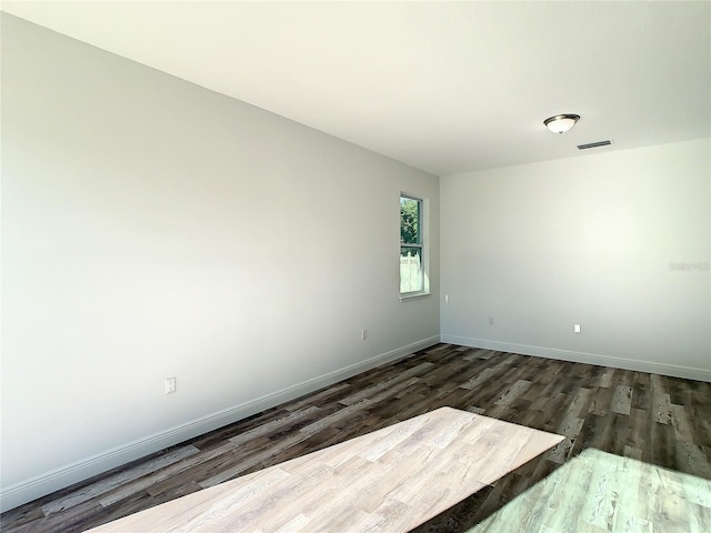 spare room featuring dark wood-type flooring