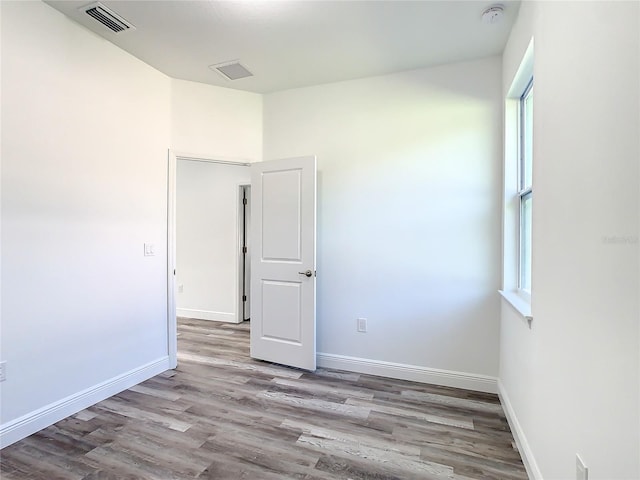 spare room with light wood-type flooring and a healthy amount of sunlight